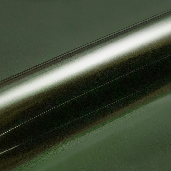 Metallic dark green vinyl wrap roll on a green background