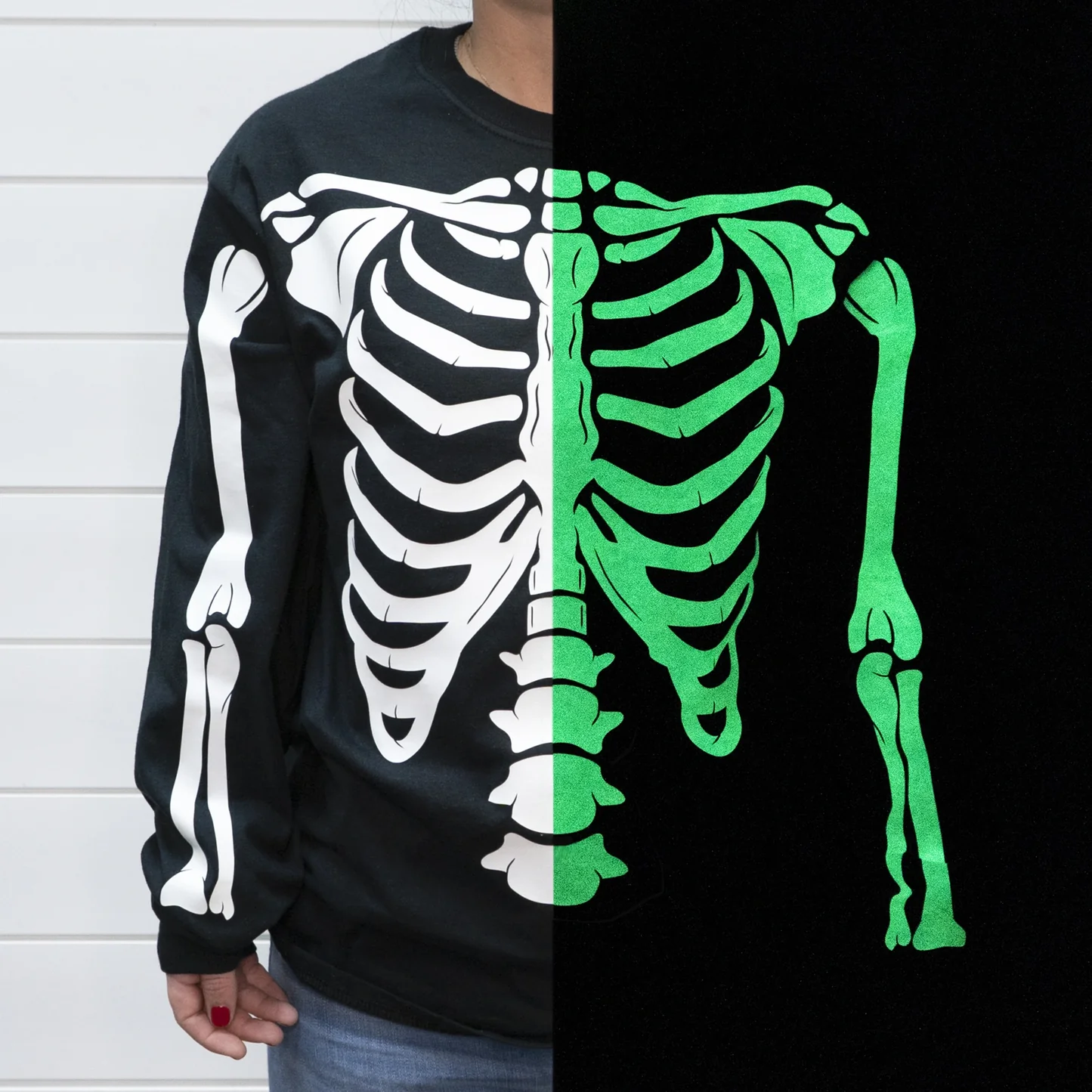 Black sweatshirt with a skeleton design split between white and green on a black background.