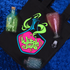 Black tray with 'Witch Juice' design, bottle, glass, and ice cubes on a blue textured surface
