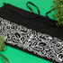 Black apron with white floral patterns on a green background