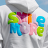 White hoodie with colorful 'Smile More' text on a clear blue sky background