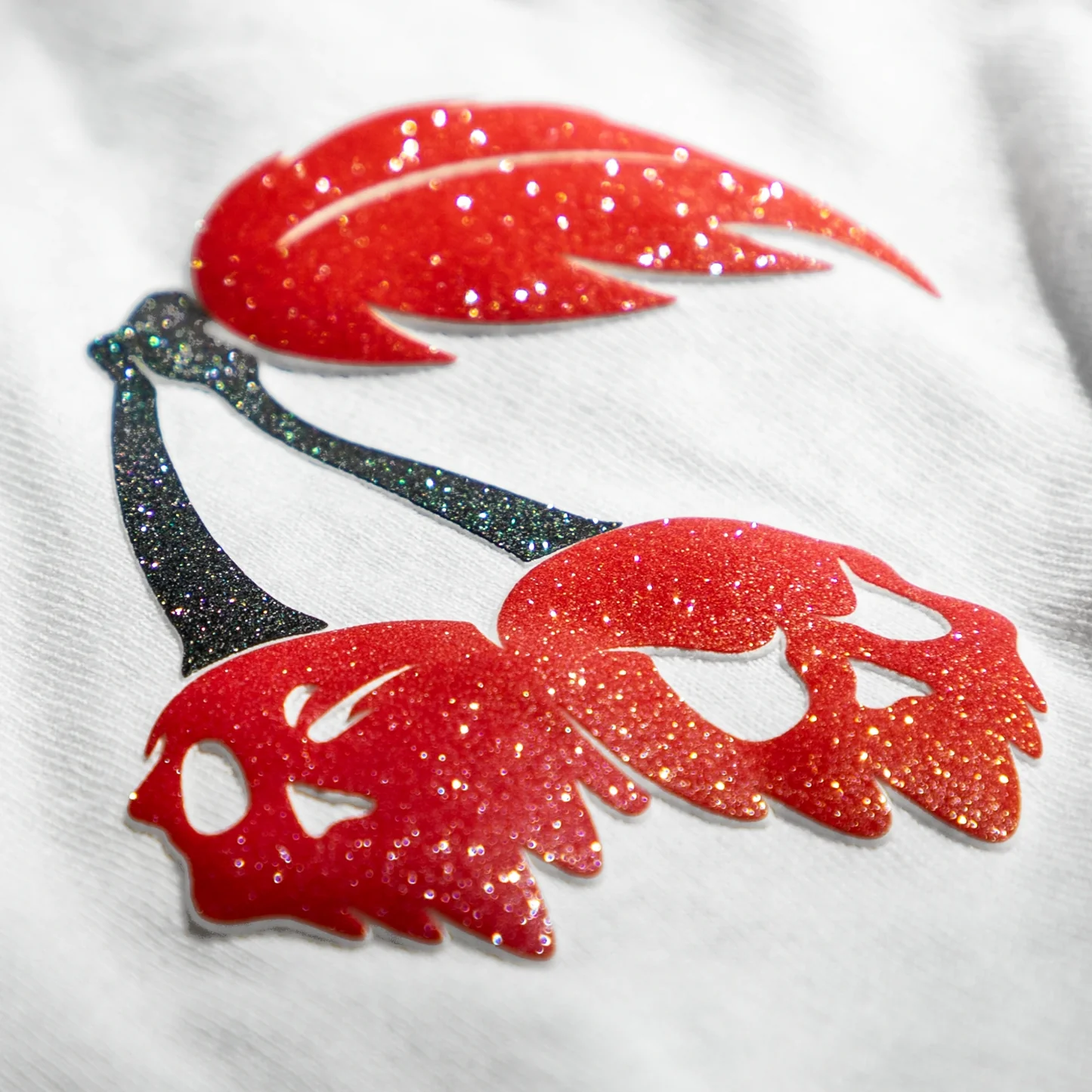 Close-up of red and black glittery designs on a white background