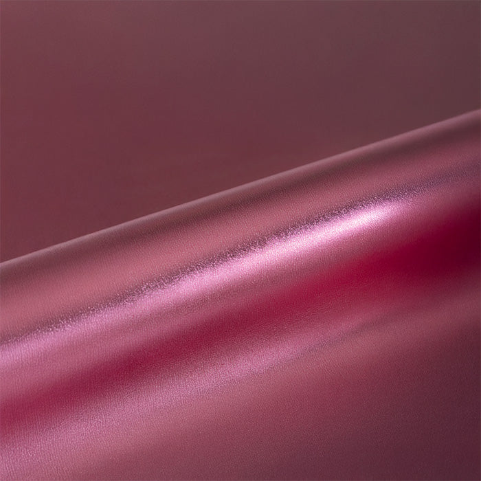 Close-up of a pinkish-red vinyl roll with a subtle texture.