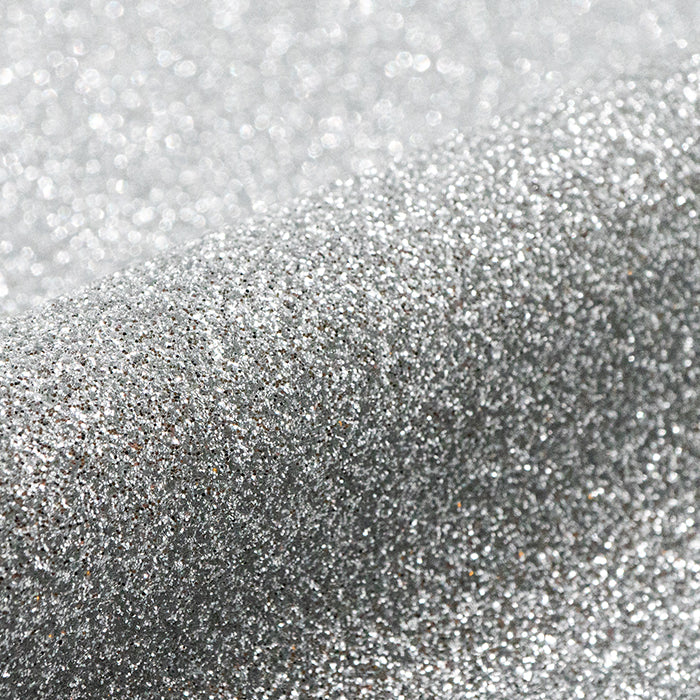 Close-up of silver glitter on a light gray background