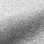 Close-up of silver glitter on a light gray background