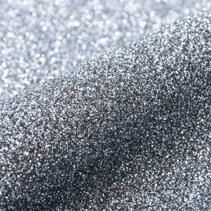Close-up of silver glitter on a textured surface