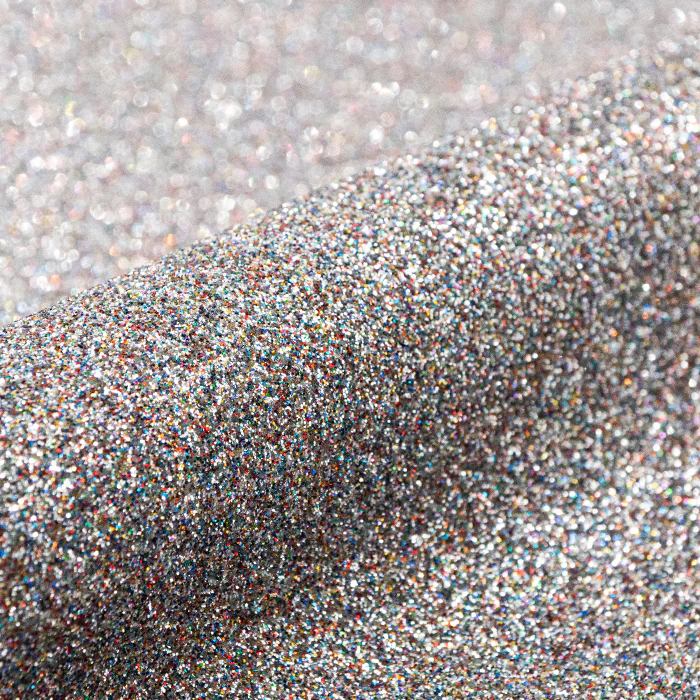 Close-up of silver glitter on a light gray background