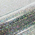 Close-up of a glittery vinyl with multicolored dots on a textured surface.