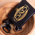 Black cardholder with 'National Bank of Dad' design on a wooden surface with keys.