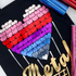 Colorful heart-shaped confetti on a black surface with tools and metallic text.