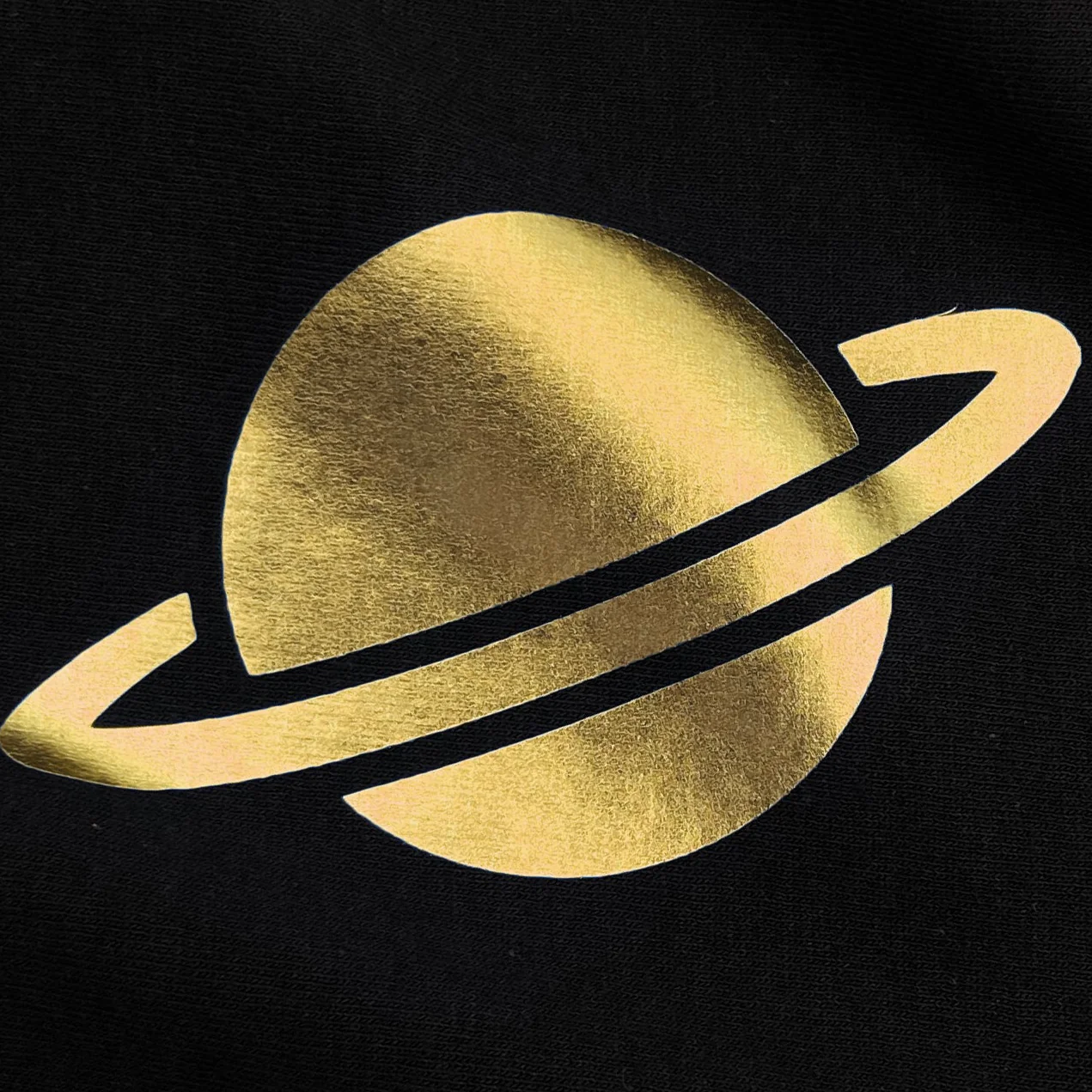 Gold Saturn-like symbol on a black background