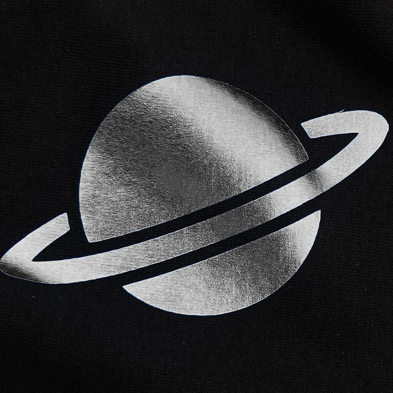 Black and white illustration of a planet with rings on a black background