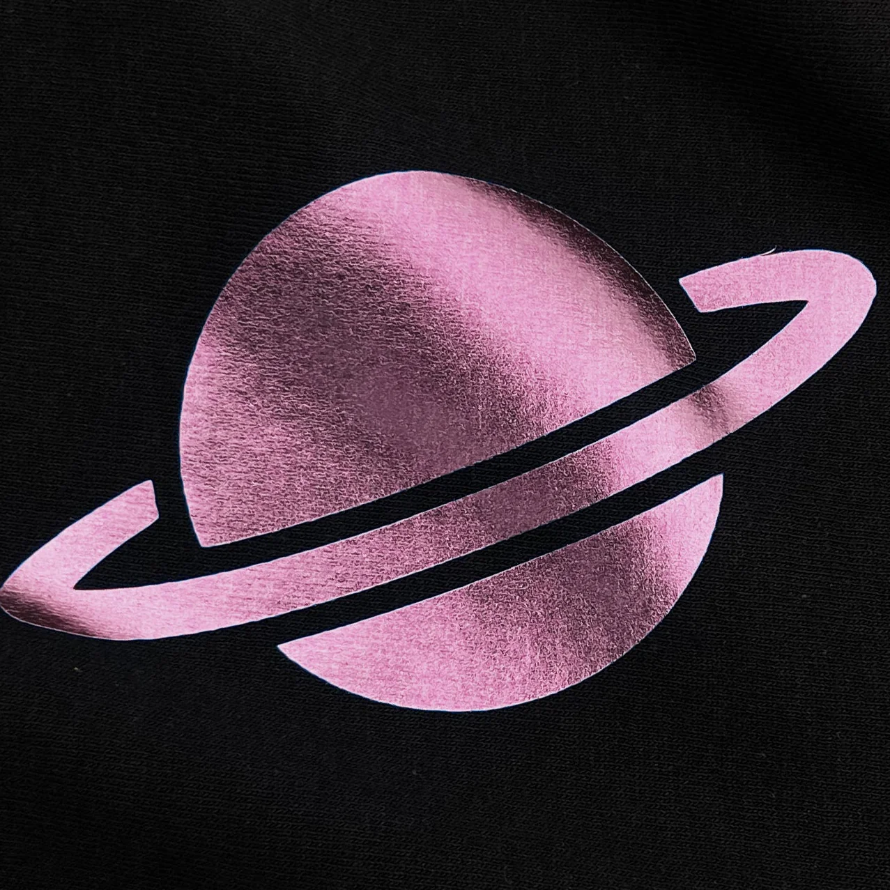 Pink planet with rings on a black background