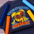 Black t-shirt with a yellow clock graphic and text 'There's no time like the present' on a wooden surface.