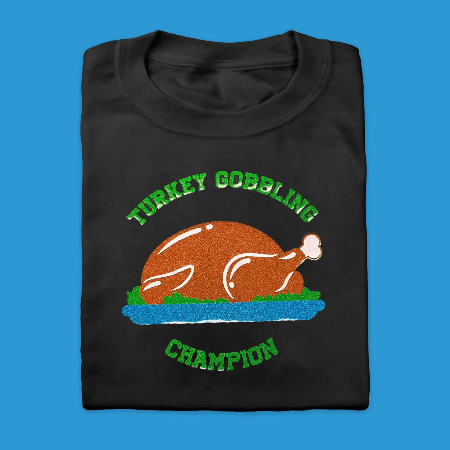 Black t-shirt with a turkey graphic and 'Turkey Gobbling Champion' text on a blue background