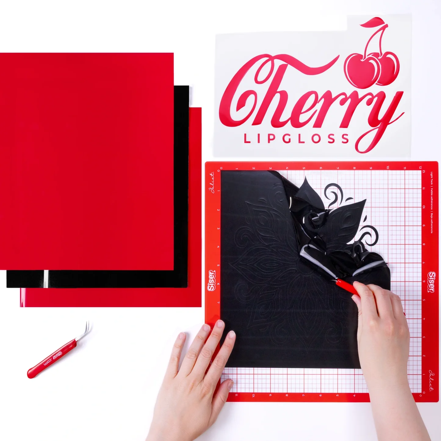 Cricut cutting machine with materials and a 'Cherry Lipgloss' design on a white background