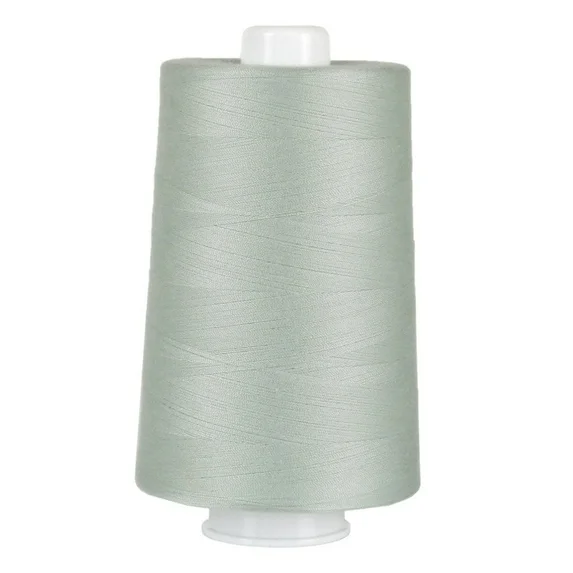 Spool of light gray thread on a white background