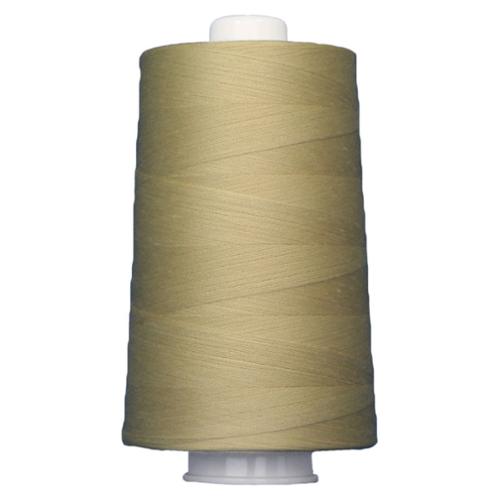 Large spool of beige thread on a white background