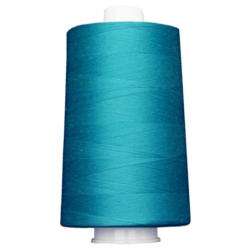 Large spool of teal thread on a white background