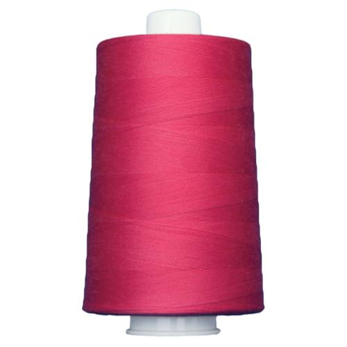 Spool of pink thread on a white background