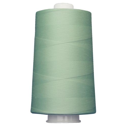Large spool of light green thread on a white background