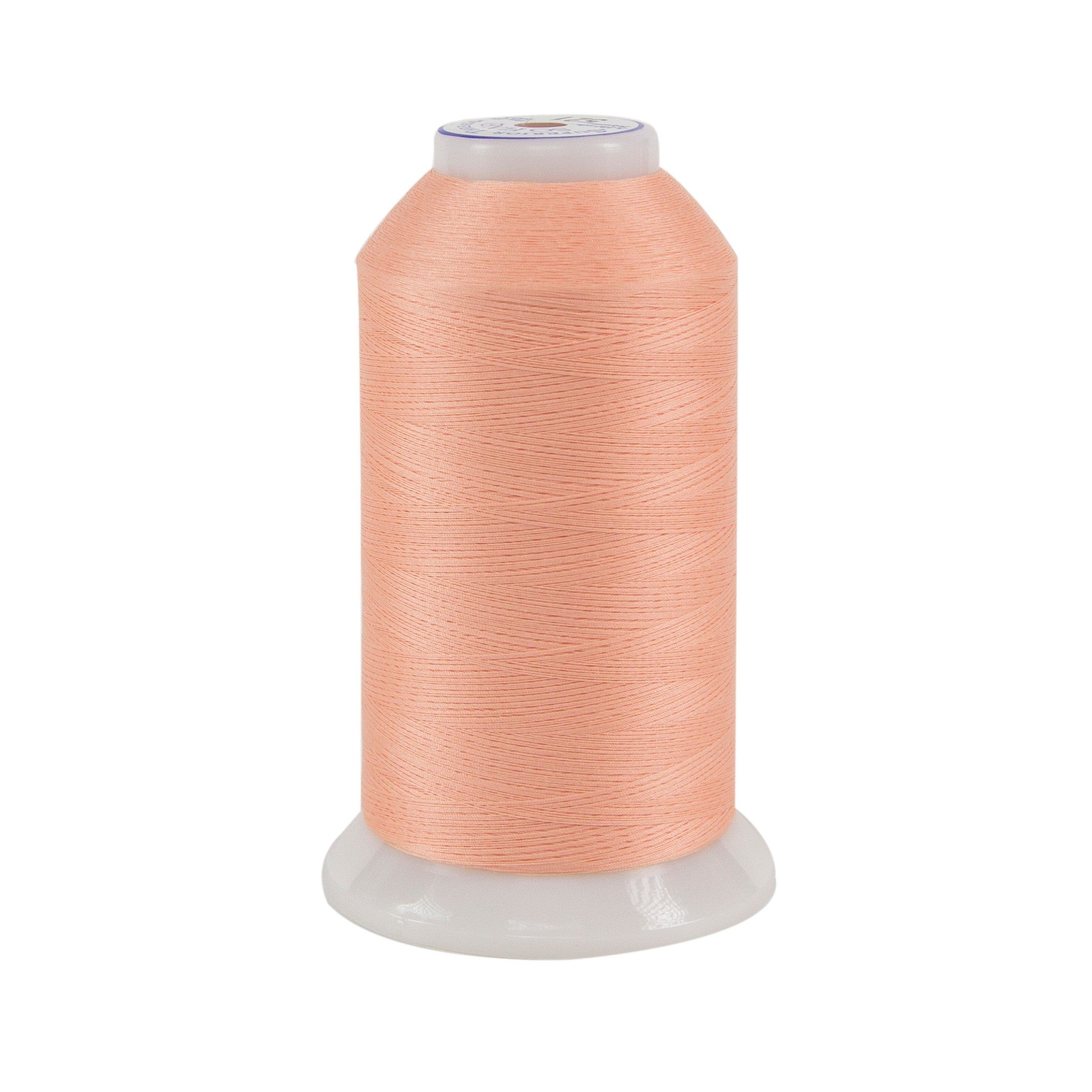 Peach colored spool of thread on a white background