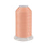 Peach colored spool of thread on a white background
