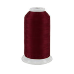 Spool of dark red thread on a white background