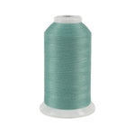 Spool of teal thread on a white background