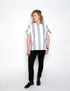 Person wearing a black and white striped shirt with black pants on a white background