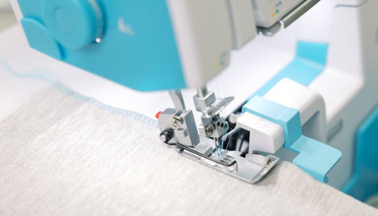 Close-up of a sewing machine needle in action on fabric
