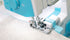 Close-up of a sewing machine needle in action on fabric