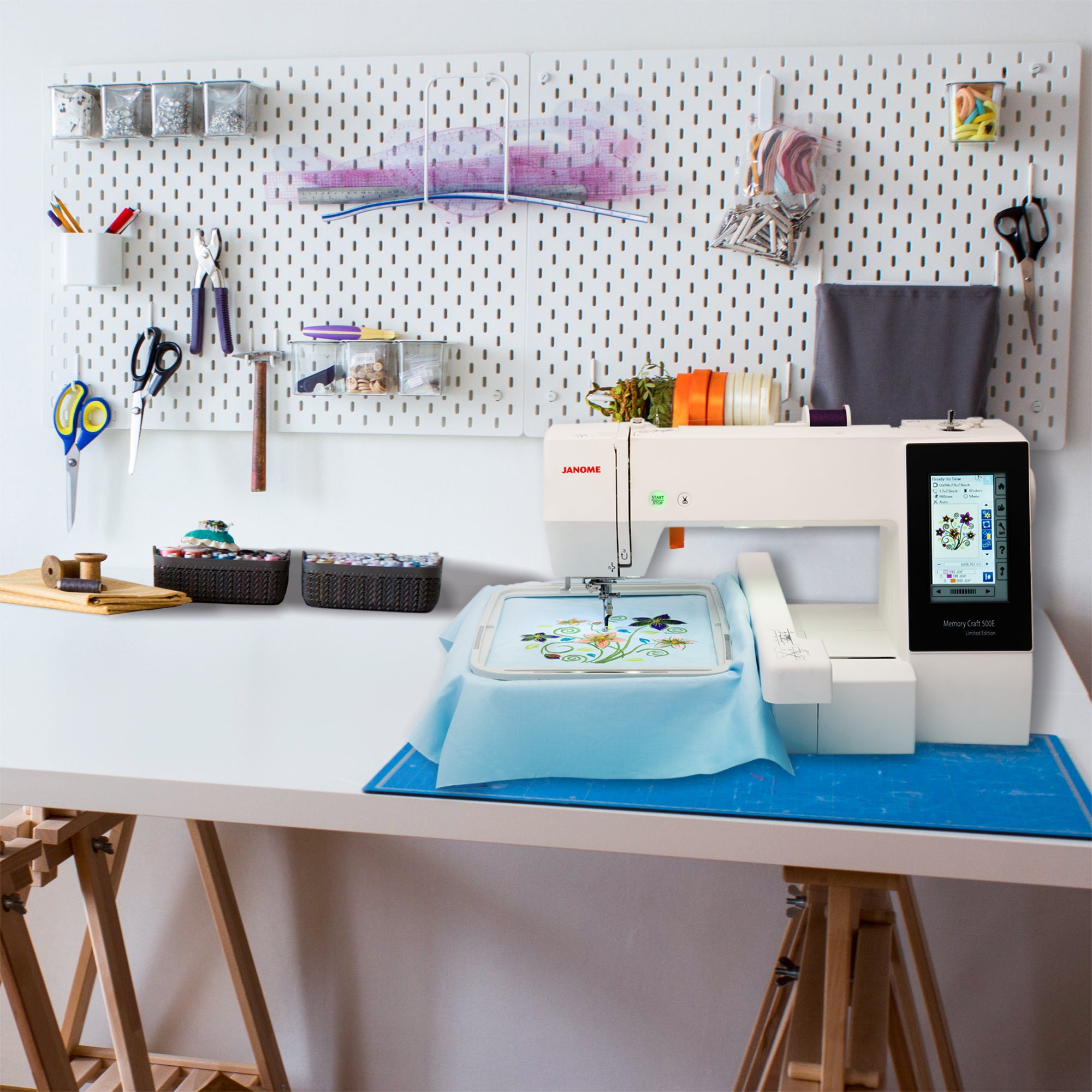 image of the Janome Memory Craft 500ELE Embroidery Machine 11x.7.9 with a hoop and embroidery item attached on a sewing room table