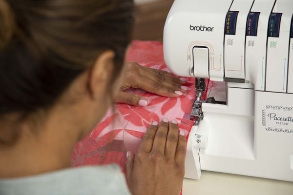 image of a woman using the Brother Pacesetter PS3734T Serger Sewing Machine to sew an item