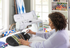 image of a woman using the Brother Innov-is BQ3100 eleven and a quarter inch Sewing and Quilting Machine and the included laser guide to sew an item