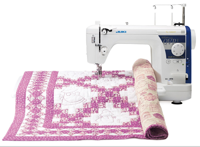 front facing image of the JUKI Haruka-TL18QVP Quilting Machine with a pink quilt attached