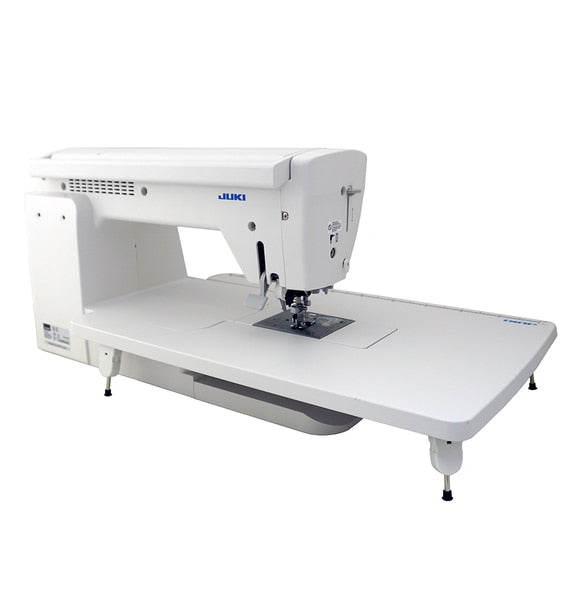 angled image of the JUKI HZL-NX7 Kirei Professional Quality Sewing and Quilting Machine with a table