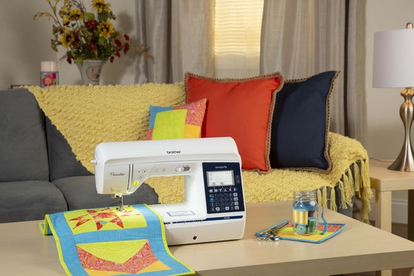 image of the Brother Pacesetter PS700 eight point three by four point one Sewing and Quilting Machine on a table with a quilting example and supplies
