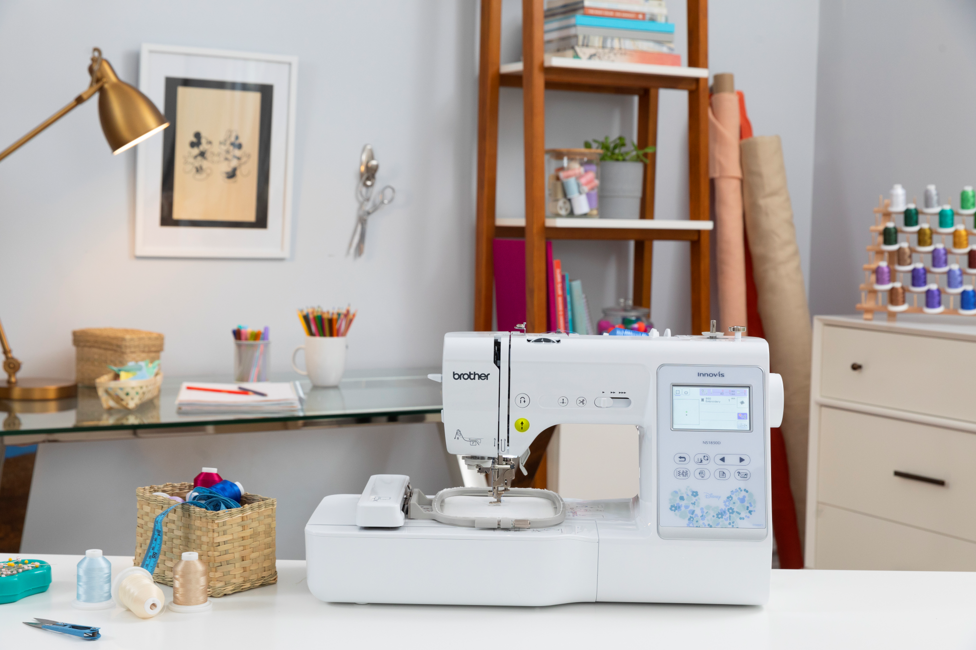 image of the Brother Innov-is NS1850D four by four Sewing and Embroidery Machine on a table with sewing supplies