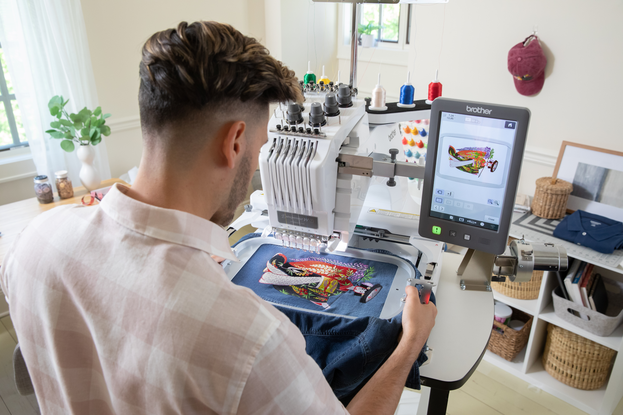 image of a man using Brother Entrepeneur W PR680W twelve by eight six needle embroidery machine to embroider a denim jacket