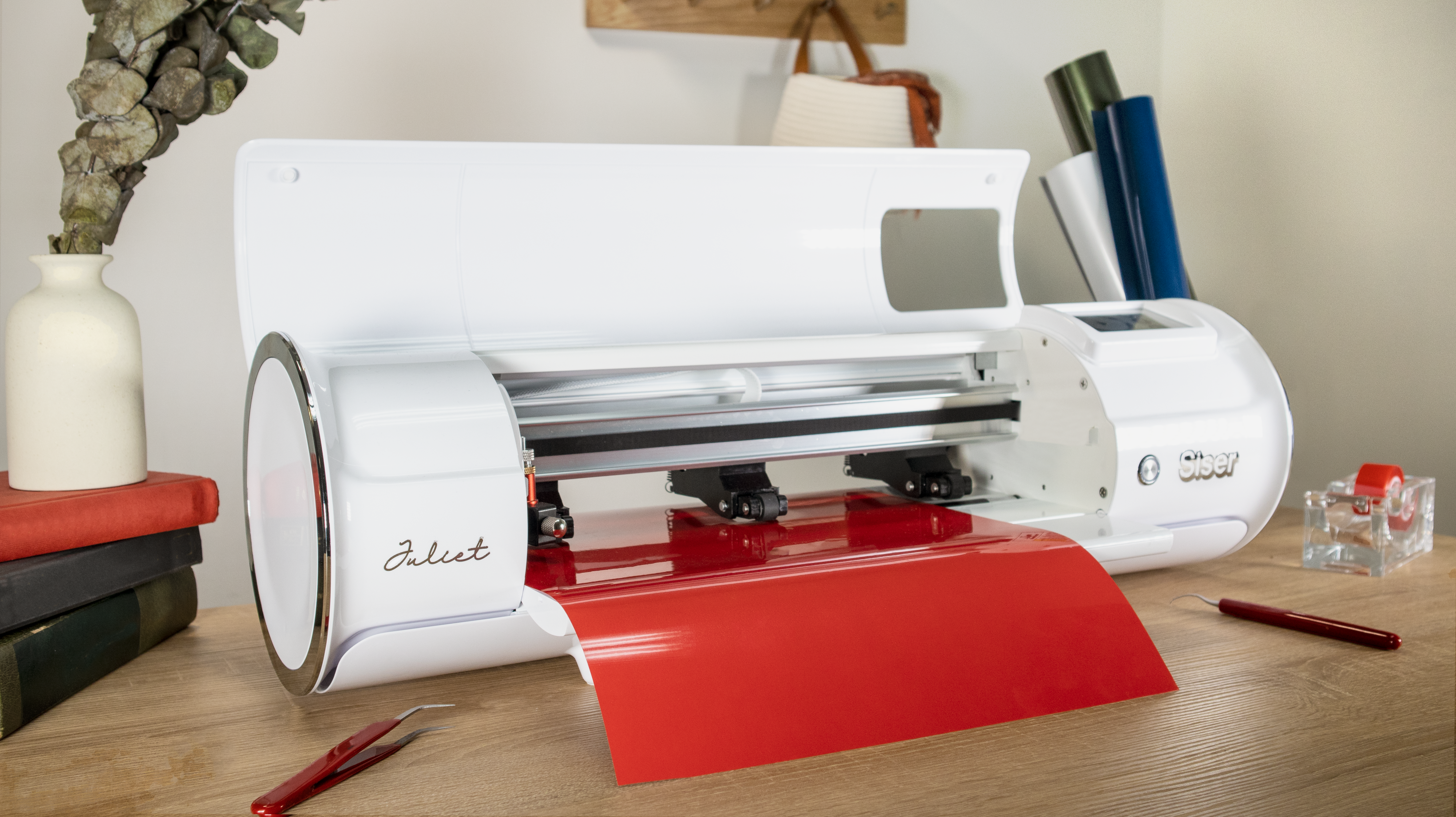 image of the Siser Juliet 12" Vinyl Craft Cutting Machine with red vinyl on a desk