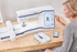 image of a woman using the Brother Stellaire Innov-is XE1 fourteen by nine and a half Embroidery Machine and the My Design Snap Mobile App to create a design