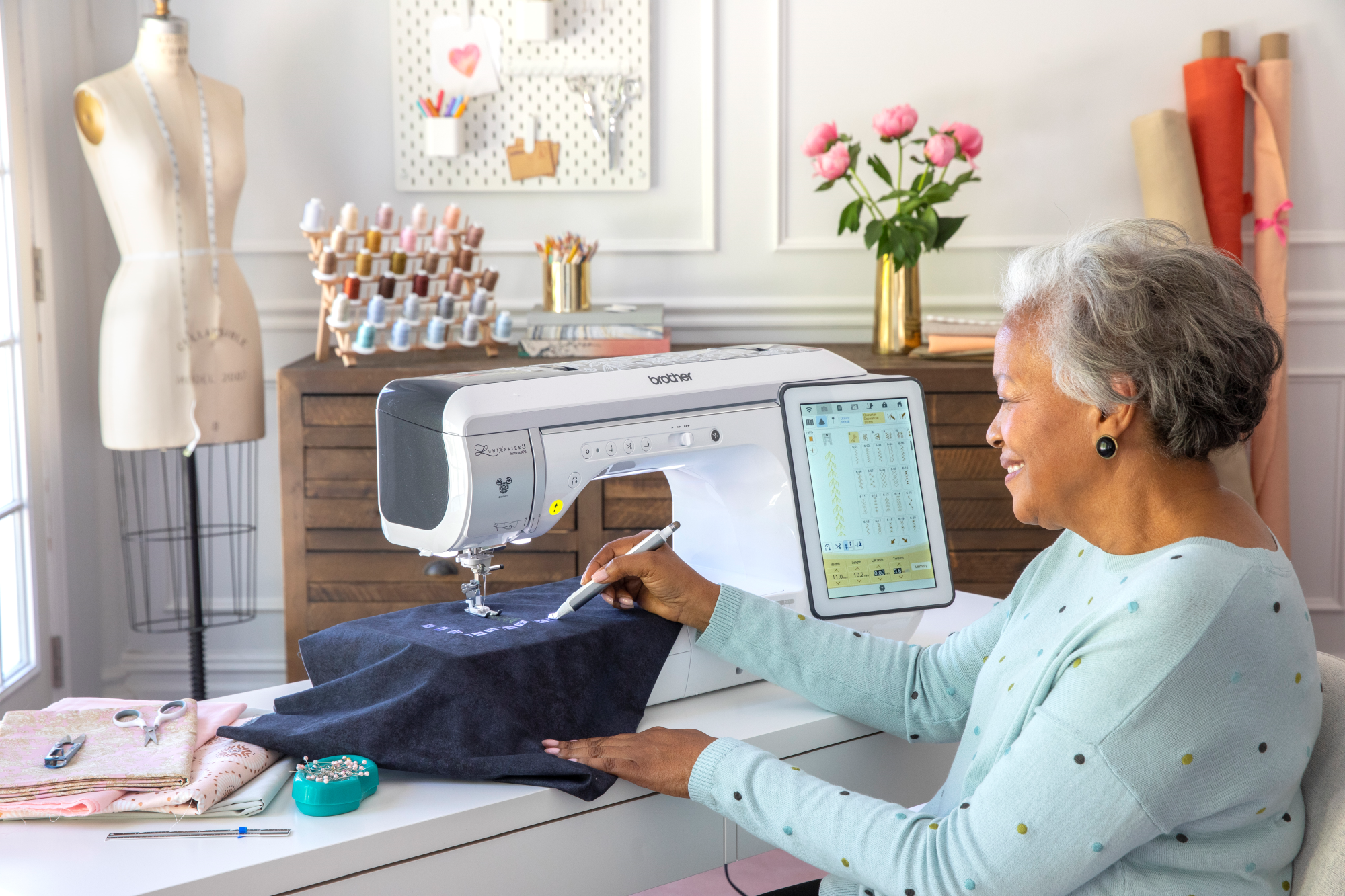 image of a woman using the Brother Luminaire 3 Innov-is XP3 sixteen by ten and a half Sewing and Embroidery Machine to embroider a shirt