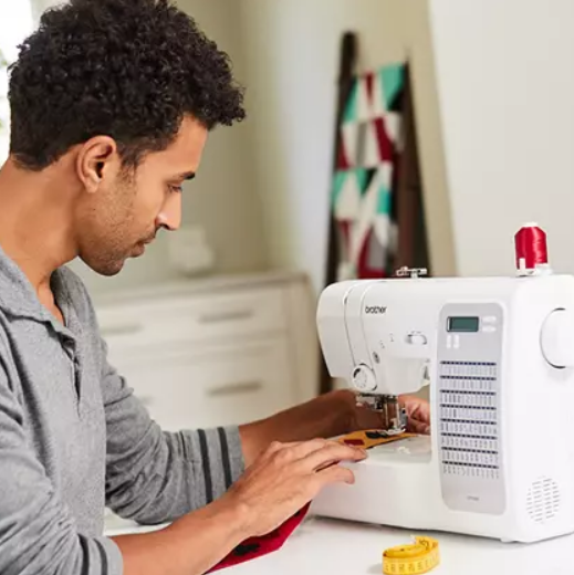 image of a man using the Brother CP100X Computerized Sewing and Quilting Machine to sew an item