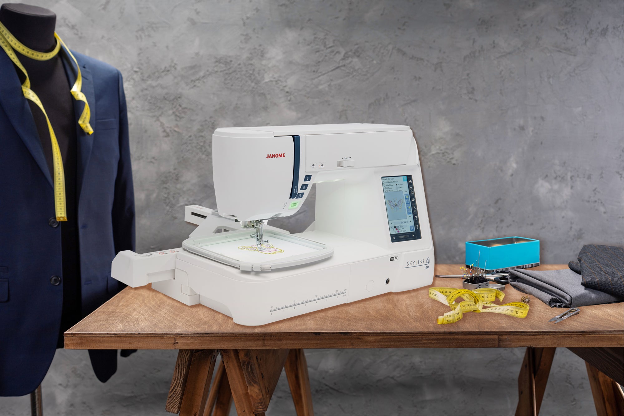 image of the Janome Skyline S9 Sewing Quilting and Embroidery Machine on a table with sewing supplies 